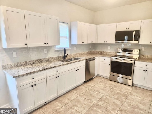 kitchen featuring white cabinetry, sink, light tile patterned floors, and stainless steel appliances