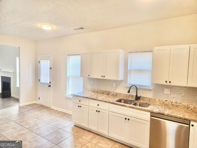 kitchen featuring white cabinetry, dishwasher, sink, and light stone countertops