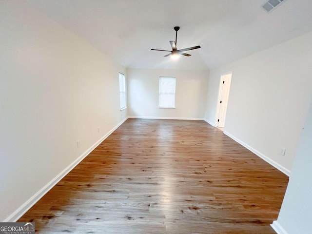 empty room with ceiling fan, lofted ceiling, and light wood-type flooring