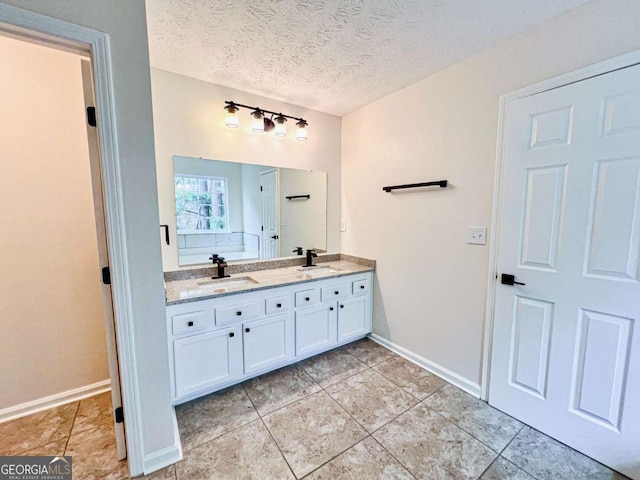 bathroom featuring vanity, tile patterned floors, and a textured ceiling