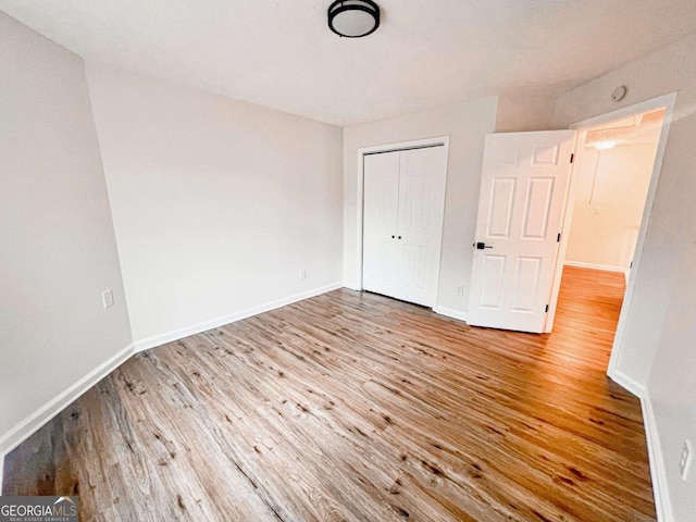 unfurnished bedroom with a closet and light hardwood / wood-style flooring