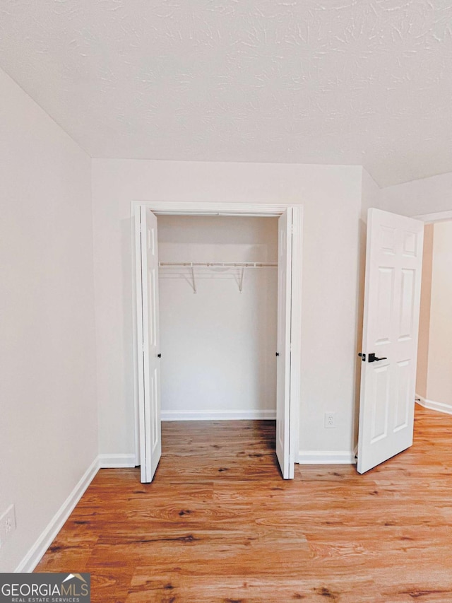 unfurnished bedroom featuring a closet and light wood-type flooring