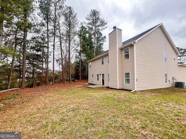 view of side of home with a yard and central AC unit