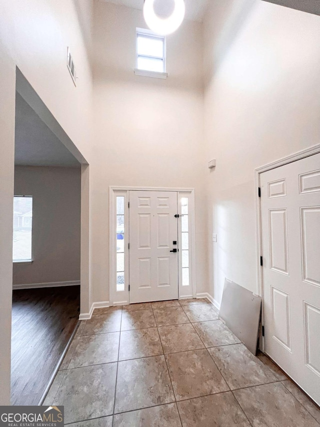 tiled foyer entrance featuring a towering ceiling