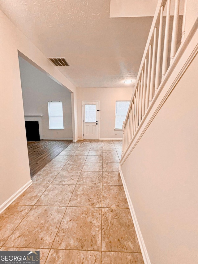 tiled entrance foyer featuring a textured ceiling