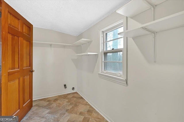 clothes washing area featuring a textured ceiling