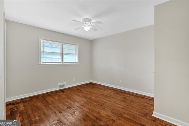 spare room with ceiling fan and dark hardwood / wood-style floors