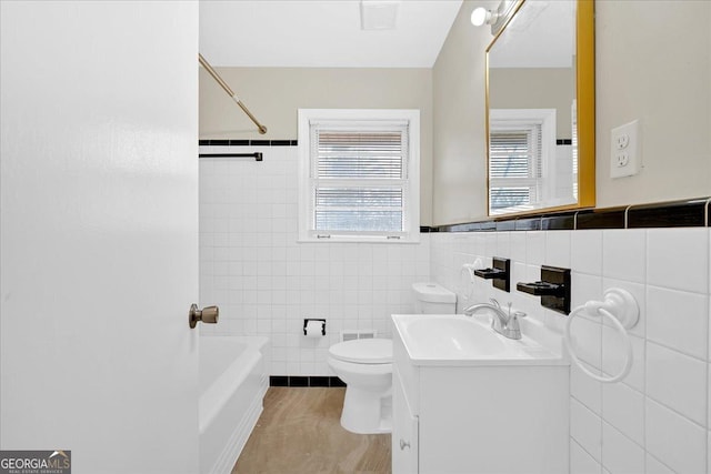 full bathroom with shower / bathtub combination, vanity, toilet, and tile walls