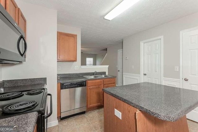 kitchen featuring sink, black appliances, and a textured ceiling