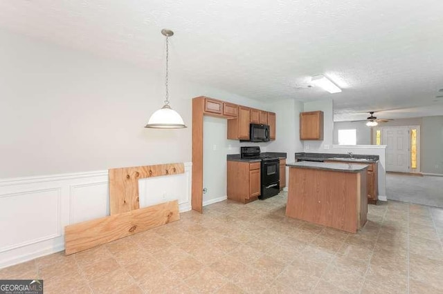 kitchen featuring hanging light fixtures, a center island, ceiling fan, black appliances, and a textured ceiling