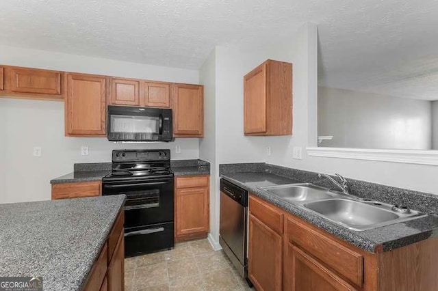 kitchen featuring sink, black appliances, and a textured ceiling