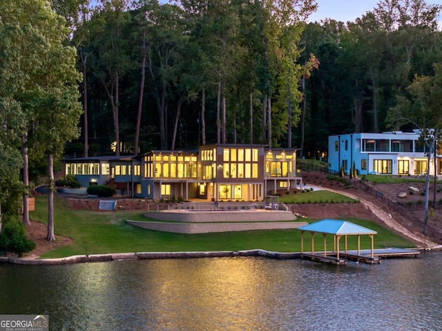 rear view of property with a lawn and a water view