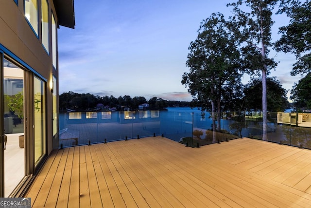 view of dock with a balcony and a water view