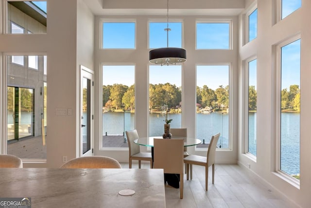 sunroom / solarium featuring a water view