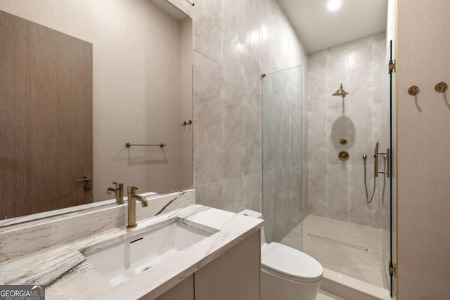 bathroom featuring vanity, a shower with door, tile walls, and toilet