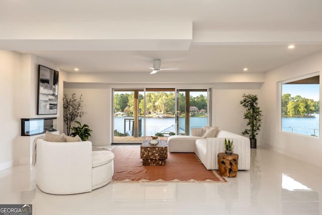 tiled living room with a water view and ceiling fan