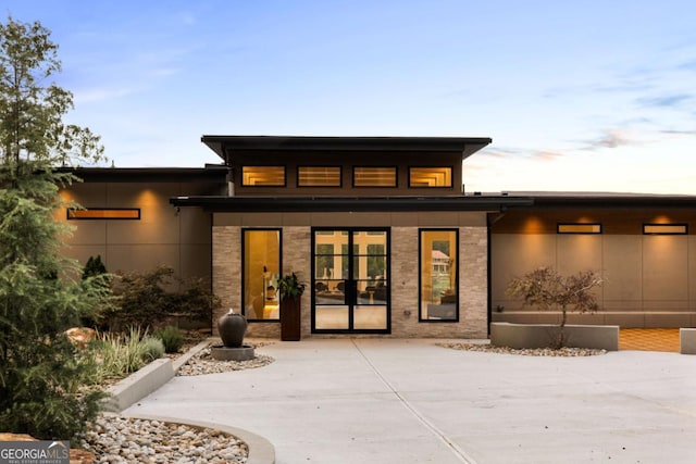 exterior entry at dusk featuring a patio