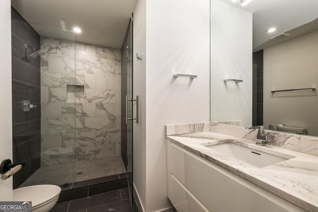 bathroom featuring vanity, tile patterned flooring, a shower with shower door, and toilet