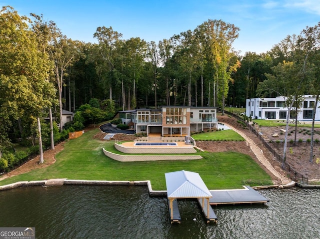 rear view of house featuring a yard, a patio area, and a water view