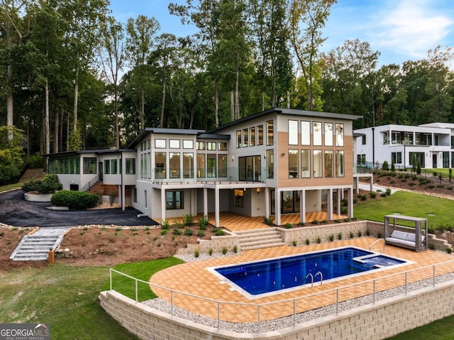 rear view of house featuring a sunroom and a patio