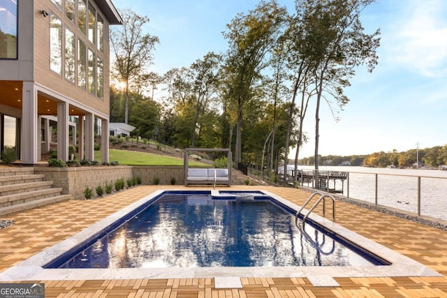 view of swimming pool with a patio and a water view