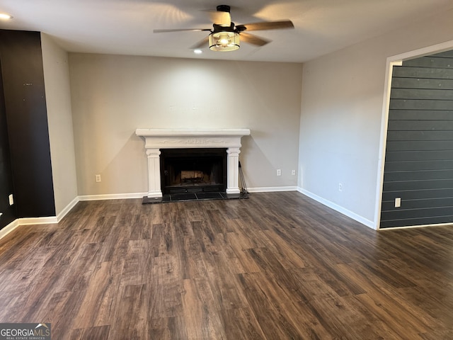 unfurnished living room featuring ceiling fan and dark hardwood / wood-style flooring