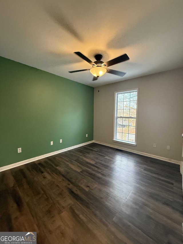 unfurnished room with ceiling fan and dark hardwood / wood-style flooring