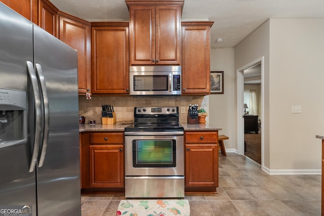 kitchen with tasteful backsplash, stainless steel appliances, and stone countertops