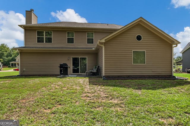 rear view of house featuring a yard