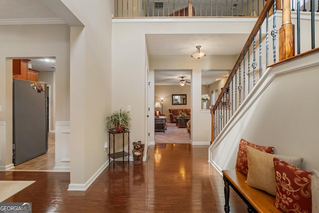 entrance foyer with ceiling fan, ornamental molding, and dark hardwood / wood-style floors