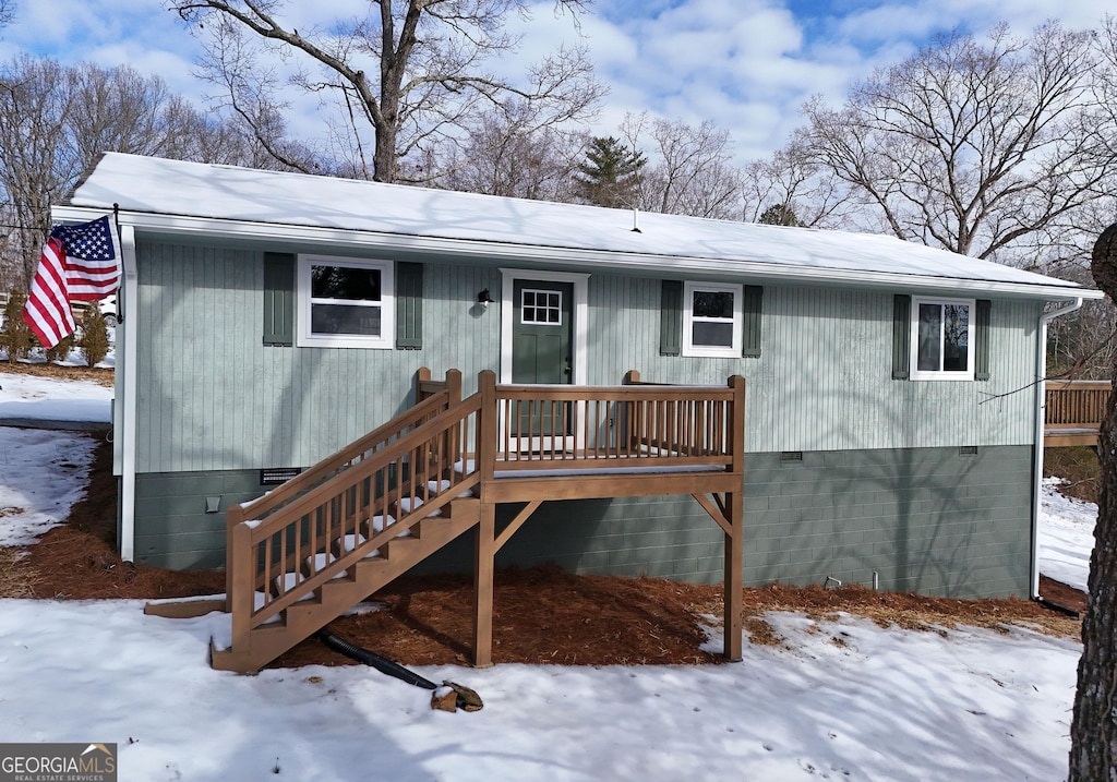 snow covered property featuring a deck