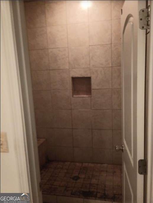 bathroom with tiled shower