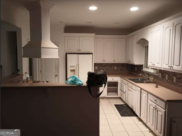 kitchen featuring sink, white fridge with ice dispenser, white cabinets, and custom range hood