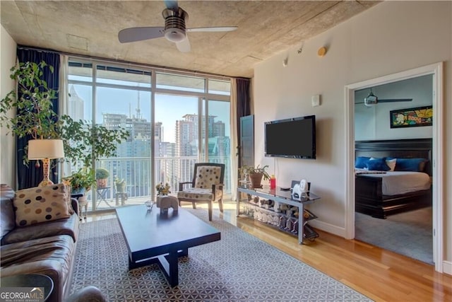 living room featuring expansive windows, hardwood / wood-style floors, and ceiling fan