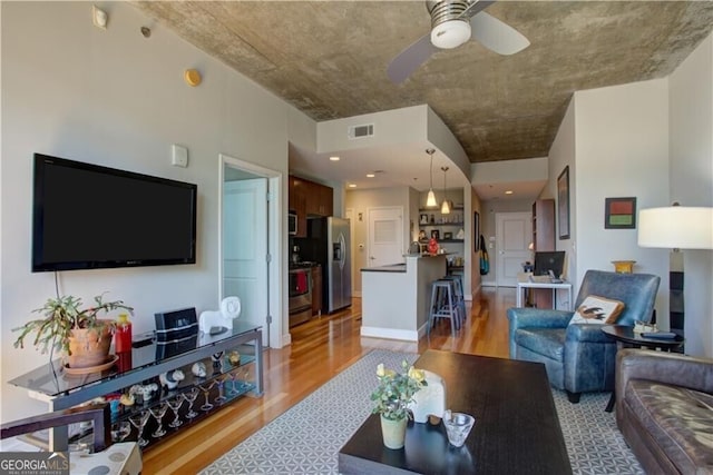 living room with ceiling fan and light hardwood / wood-style flooring