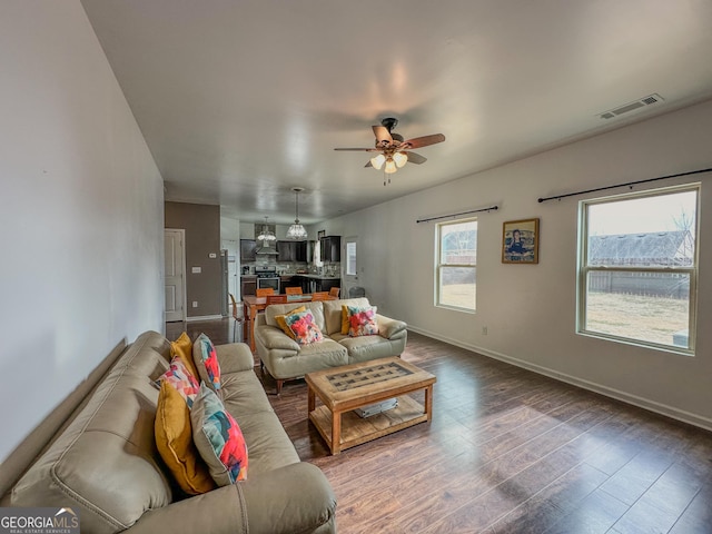 living room with dark wood-type flooring and ceiling fan