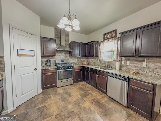 kitchen featuring sink, dark brown cabinets, appliances with stainless steel finishes, pendant lighting, and wall chimney range hood