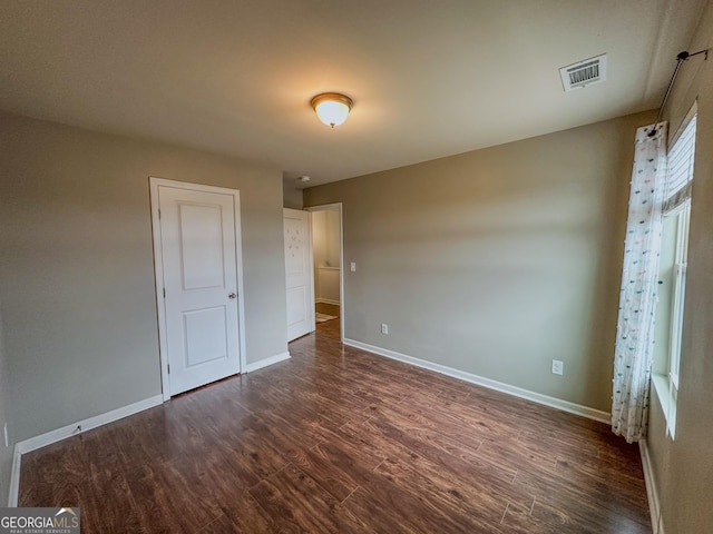 unfurnished bedroom with dark wood-type flooring