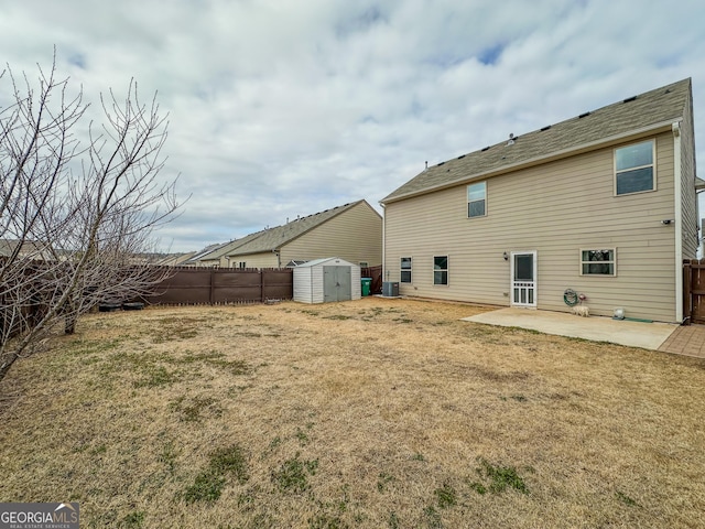 rear view of house with a storage unit, a lawn, and a patio area