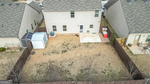 back of house with a storage shed, central AC, and a patio area