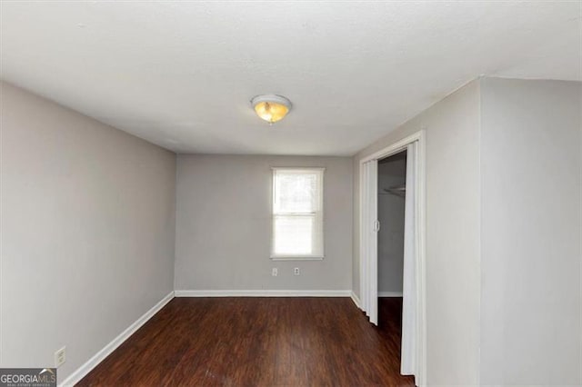 unfurnished bedroom featuring dark wood-type flooring and a closet