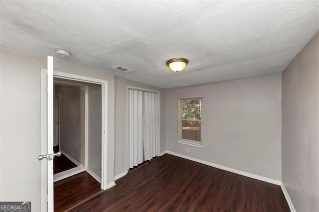 interior space featuring dark wood-type flooring and a textured ceiling