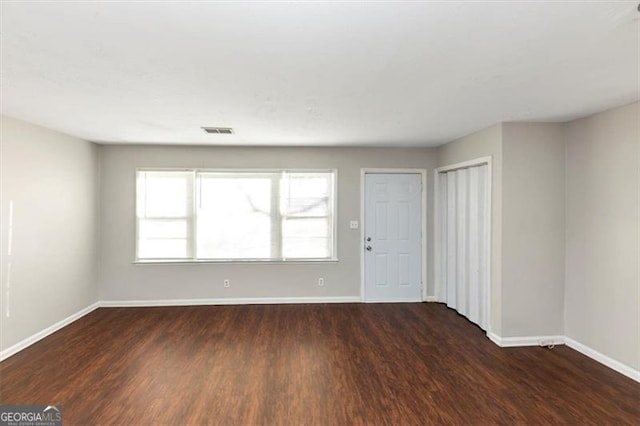 empty room with dark hardwood / wood-style flooring