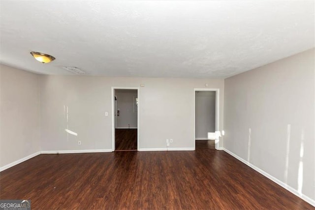 spare room featuring dark wood-type flooring