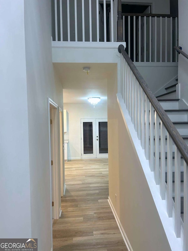 hallway featuring a towering ceiling and hardwood / wood-style floors