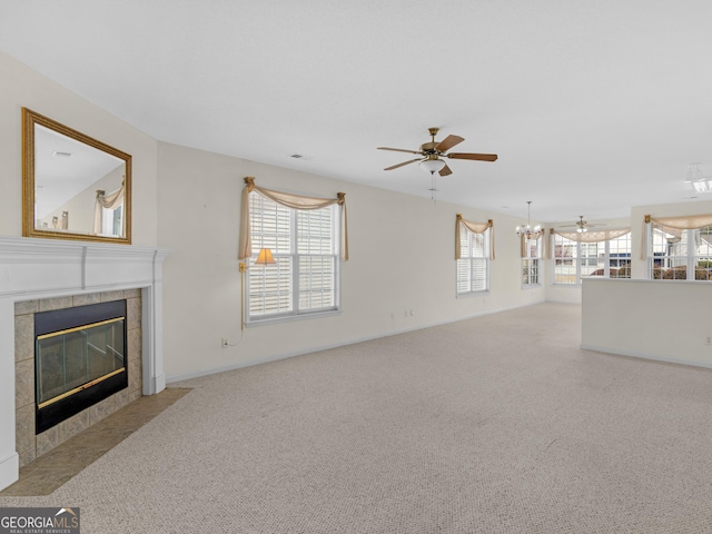 unfurnished living room featuring ceiling fan, a healthy amount of sunlight, light carpet, and a tile fireplace