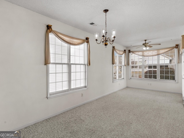 spare room with ceiling fan with notable chandelier, carpet floors, and a textured ceiling