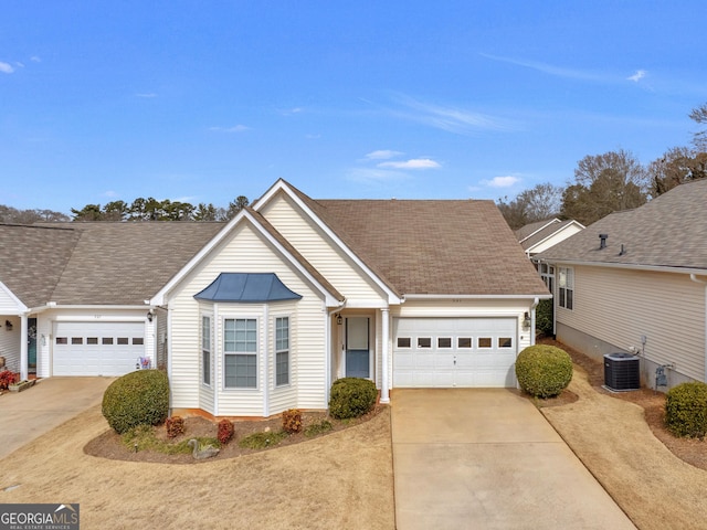 view of front of property with a garage and central AC unit