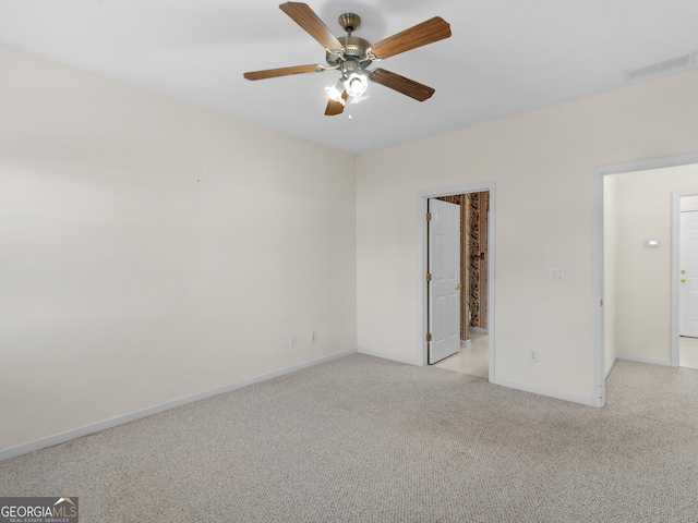 carpeted spare room featuring ceiling fan