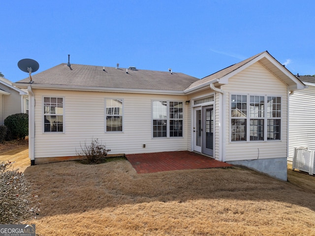 back of property with a yard and a patio